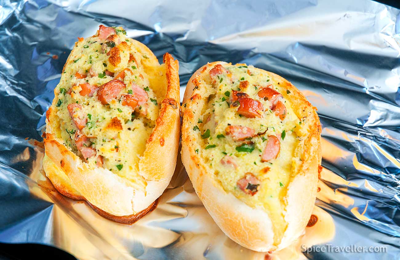 Two freshly grilled Breakfast Boats - mini baguettes stuffed with eggs, cheese and ham.