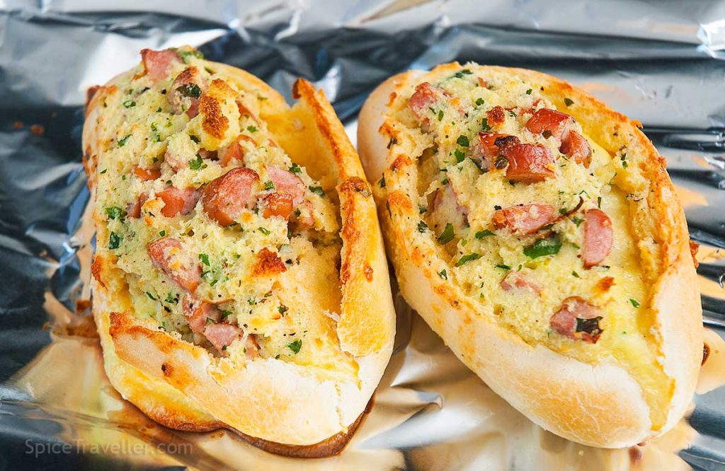 Close up of two grilled Breakfast Boats -  mini baguettes stuffed with delicious filling of eggs, ham and cheese.