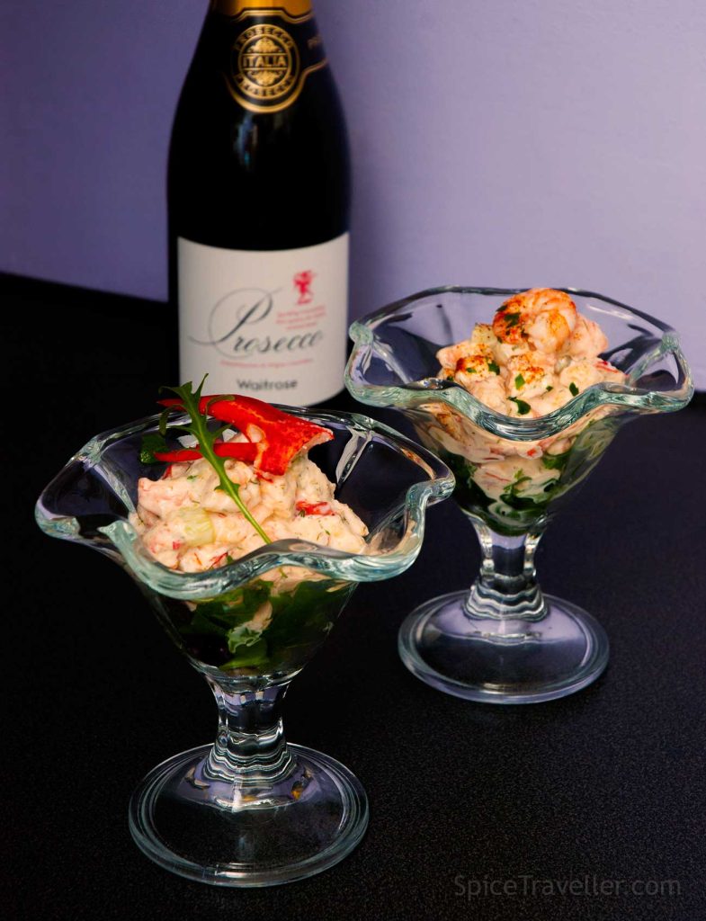 Two seafood cocktails with different dressings and a bottle of Prosecco. 