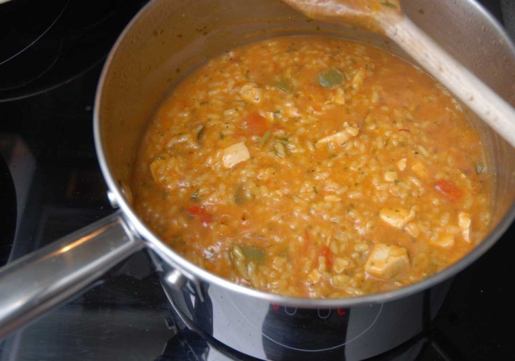 Simmering Brazilian Galinhada - chicken, peppers and rice. 