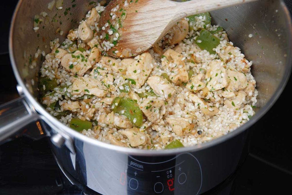 Making Brazilian galinhada - frying chicken, peppers and rice. 