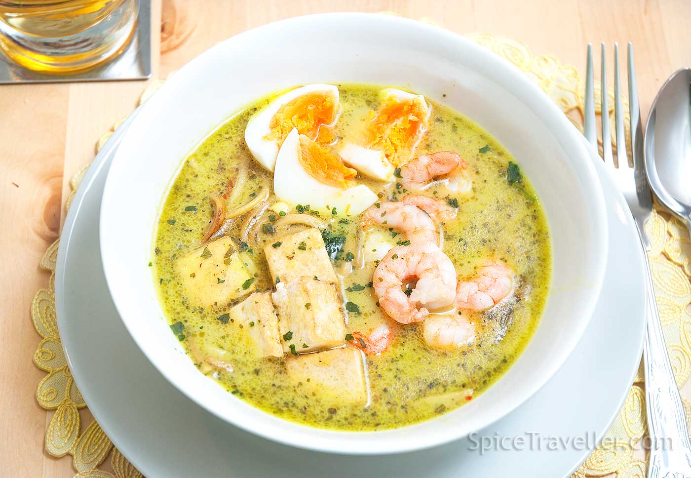 Curry Laksa noodle soup with prawns and tofu served in a white bowl.