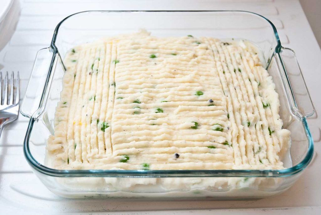 British fish pie topped with mashed potato, ready to bake.