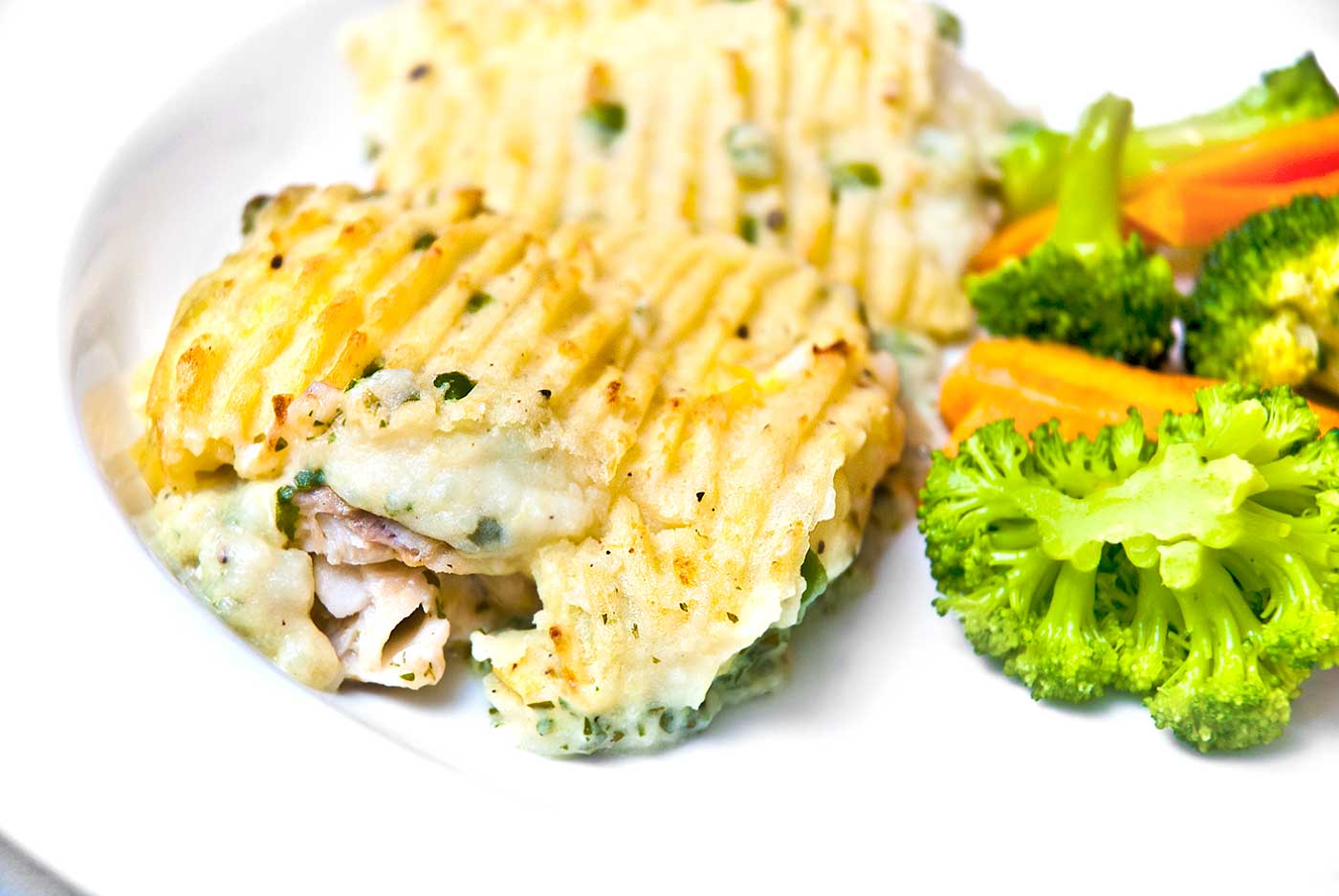 British fish pie served with broccoli and carrots.