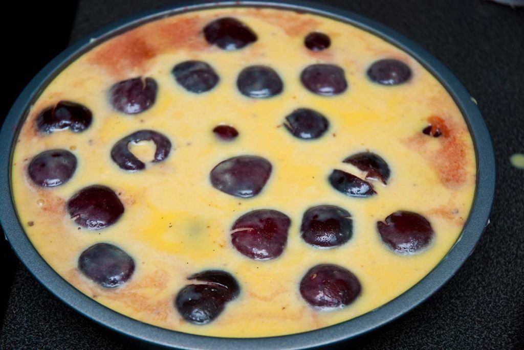 Clafoutis batter poured over cherries and ready to bake.