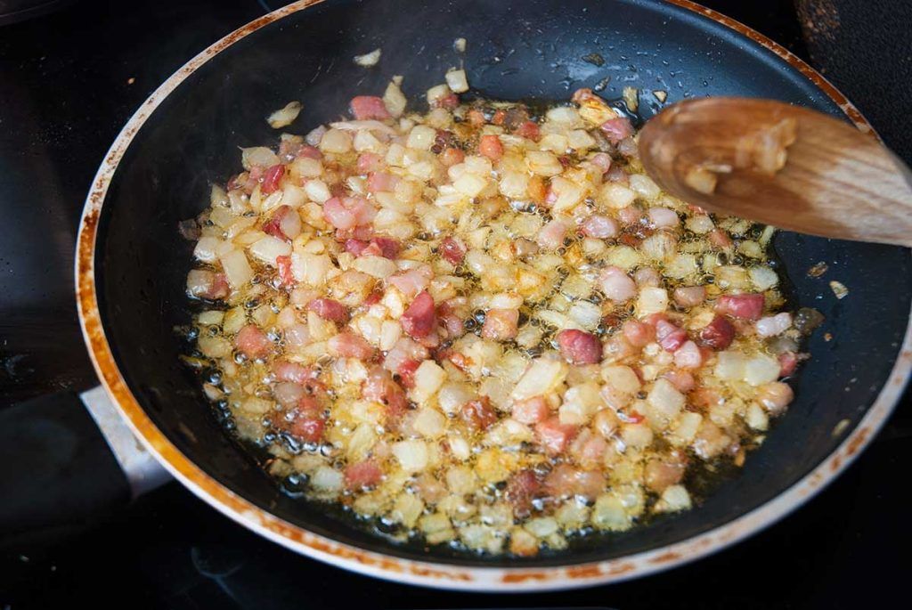 Frying chopped onion and bacon for German Bratkartoffeln.