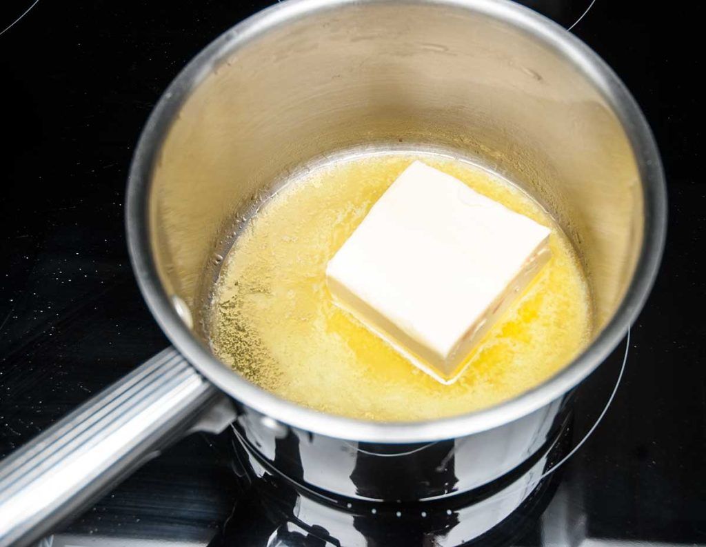 Melting block of butter in a pot.