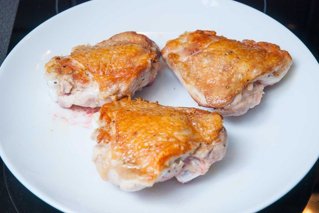 Seared chicken thighs on a plate.