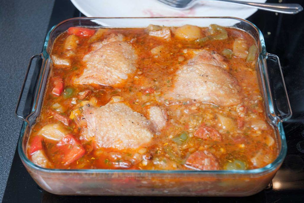 Chicken and bulgur topped with sauce, ready to bake.