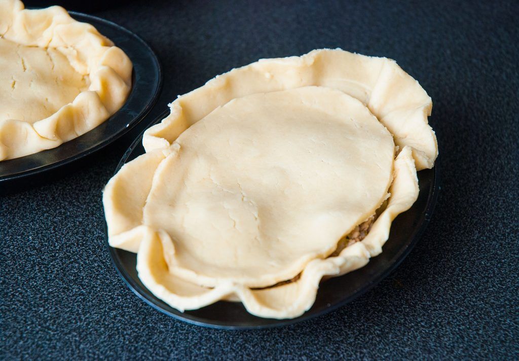 Mini Tourtiere with dough lid placed over the filling, ready to seal.