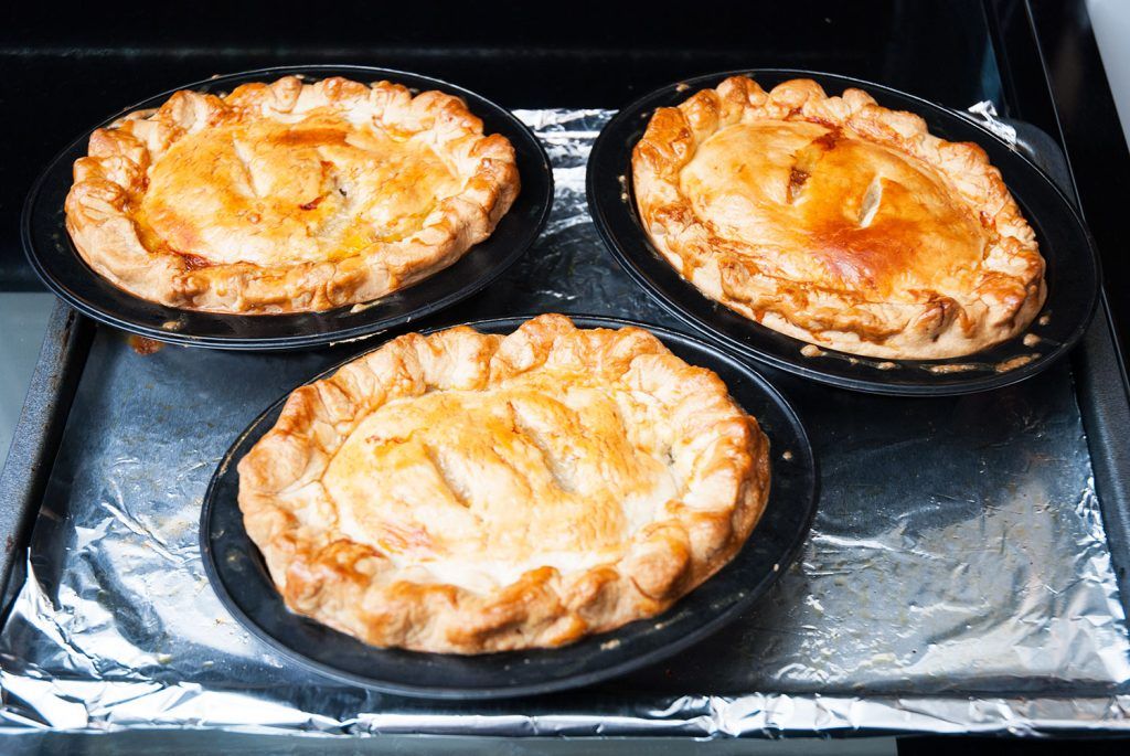 Golden baked mini Tourtiere meat pies cooling after baking.