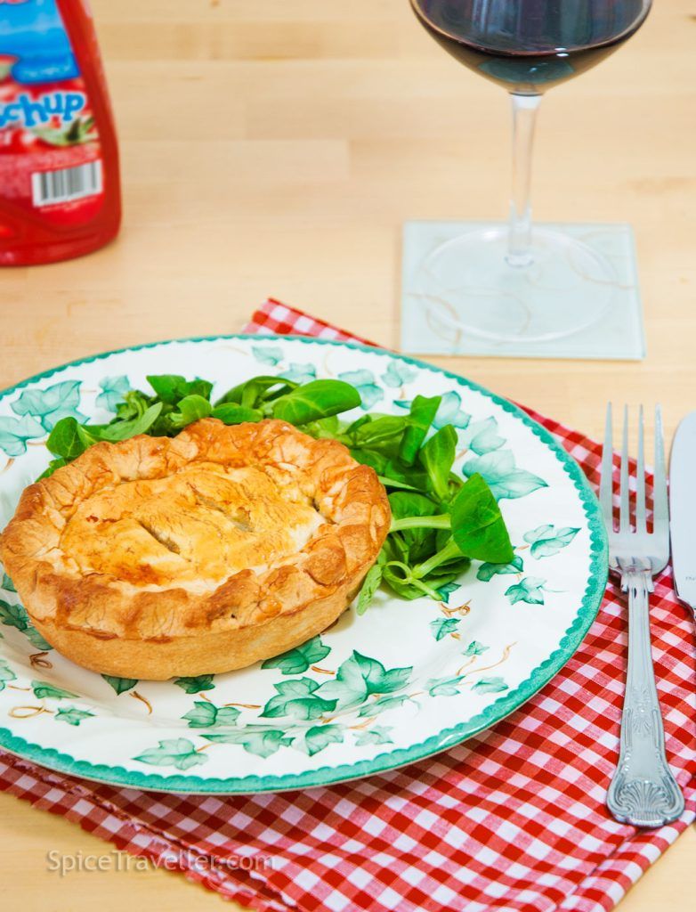 Mini Tourtiere served with salad, a tub of ketchup, and a glass of red wine.