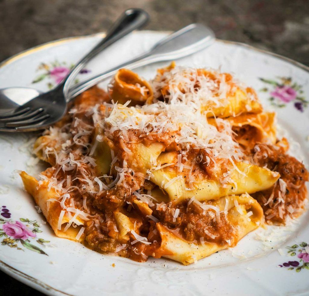 Large square-cut pasta topped with pork sauce and a thick layer of grated cheese.