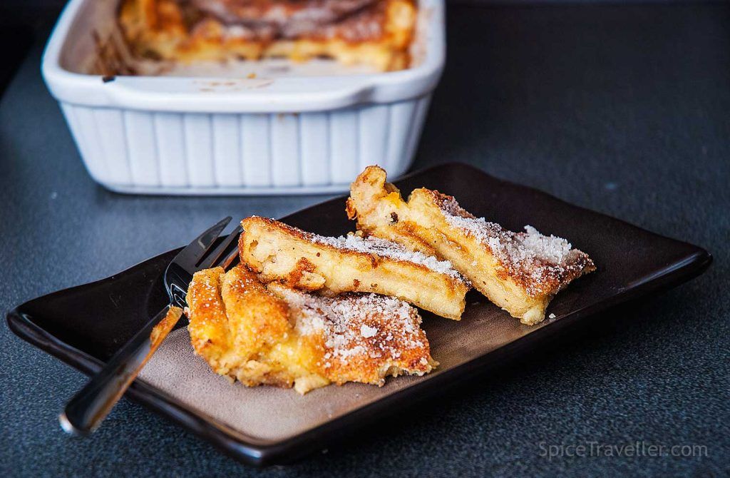 Three slices of bread and butter pudding served on a plate with apricot jam oozing