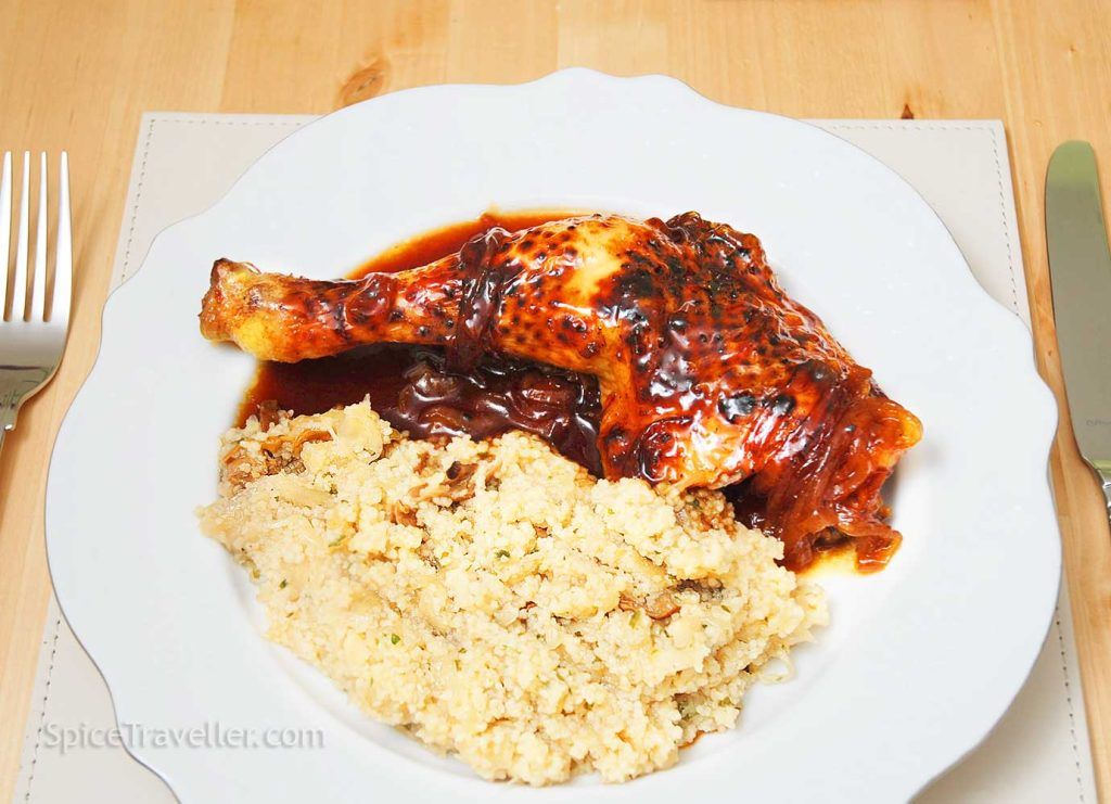 Sweet and sticky oven-baked chicken leg Texas-style served with cous cous.