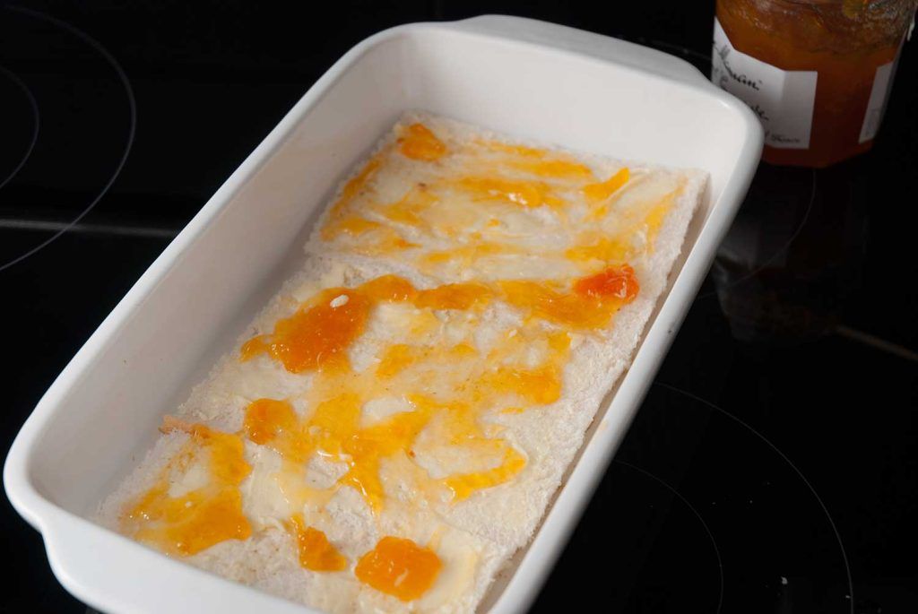 First layer of buttered bread in a baking dish, spread with apricot jam.
