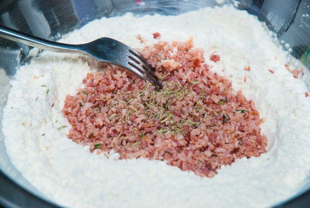 Chopped bacon and rosemary added into flour for no-yeast damper bread.