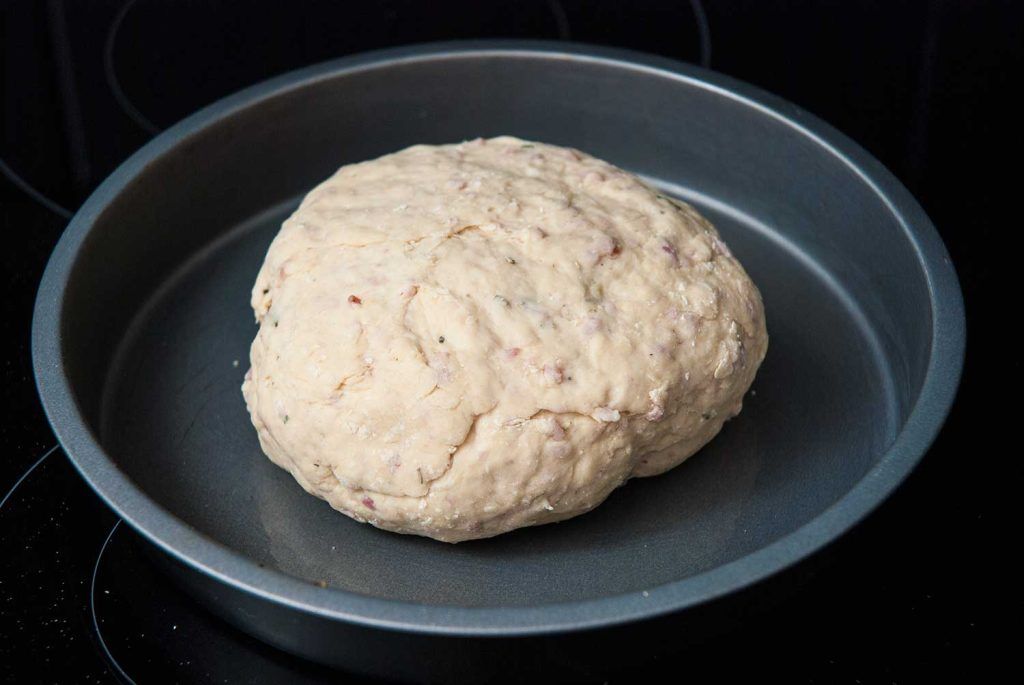 Soft damper dough ball on baking tray ready to bake in the oven.